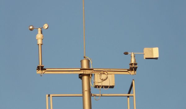 Professionelle Wetterstation im Vordergrund. Im Hintergrund blauer Himmel.